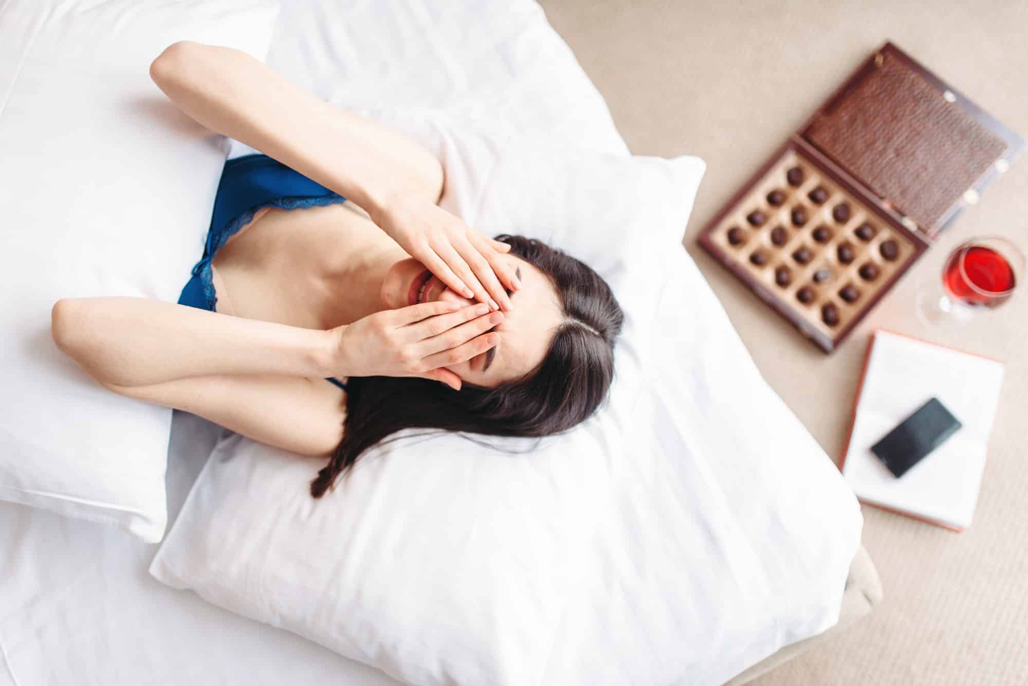 Woman lies under the blanket, top view, depression